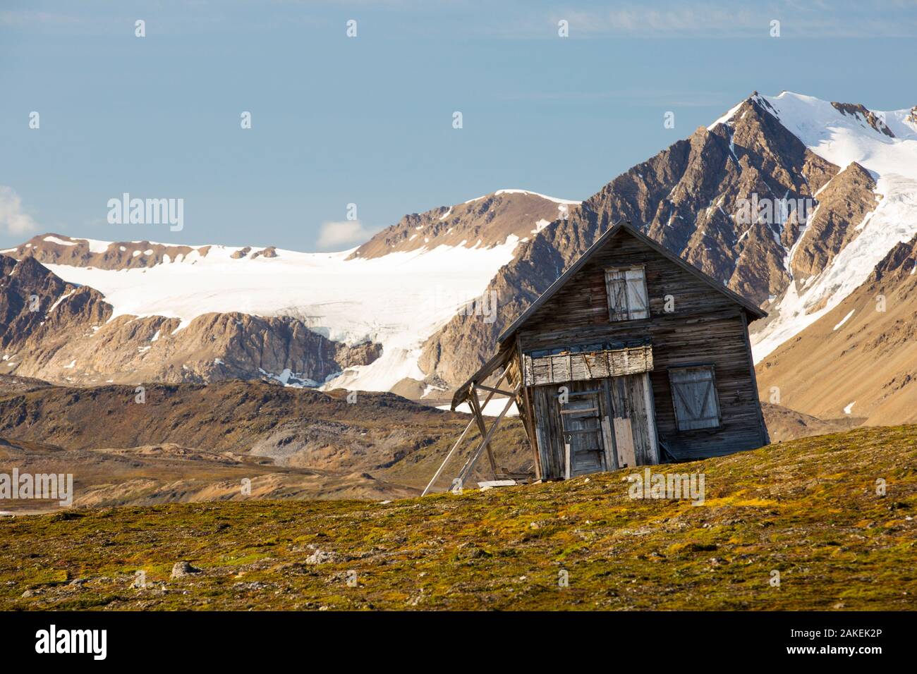 Old house at Recherchefjorden, Van Keulenfjorden, Spitsbergen, Svalbard. It is gradually sliding down slope due to solifluction and permafrost melt. Norway, July 2013. Stock Photo