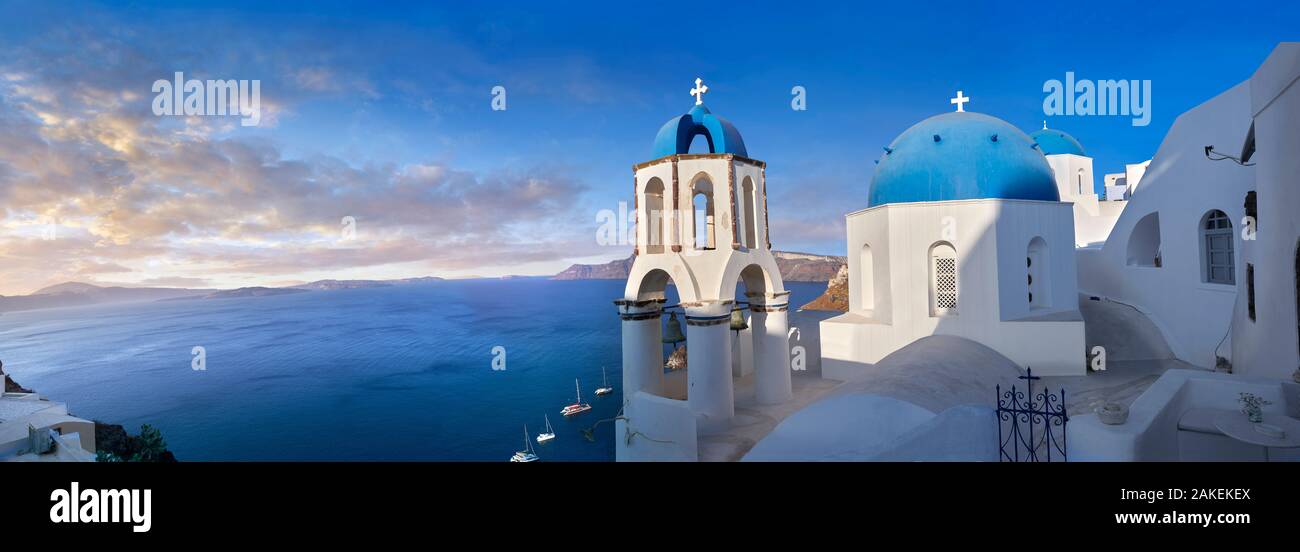 Panoramic sunset over the traditional Greek Orthodox churches of Oia (ia), Cyclades Island of  Thira, Santorini, Greece.  The settlement of Oia had be Stock Photo