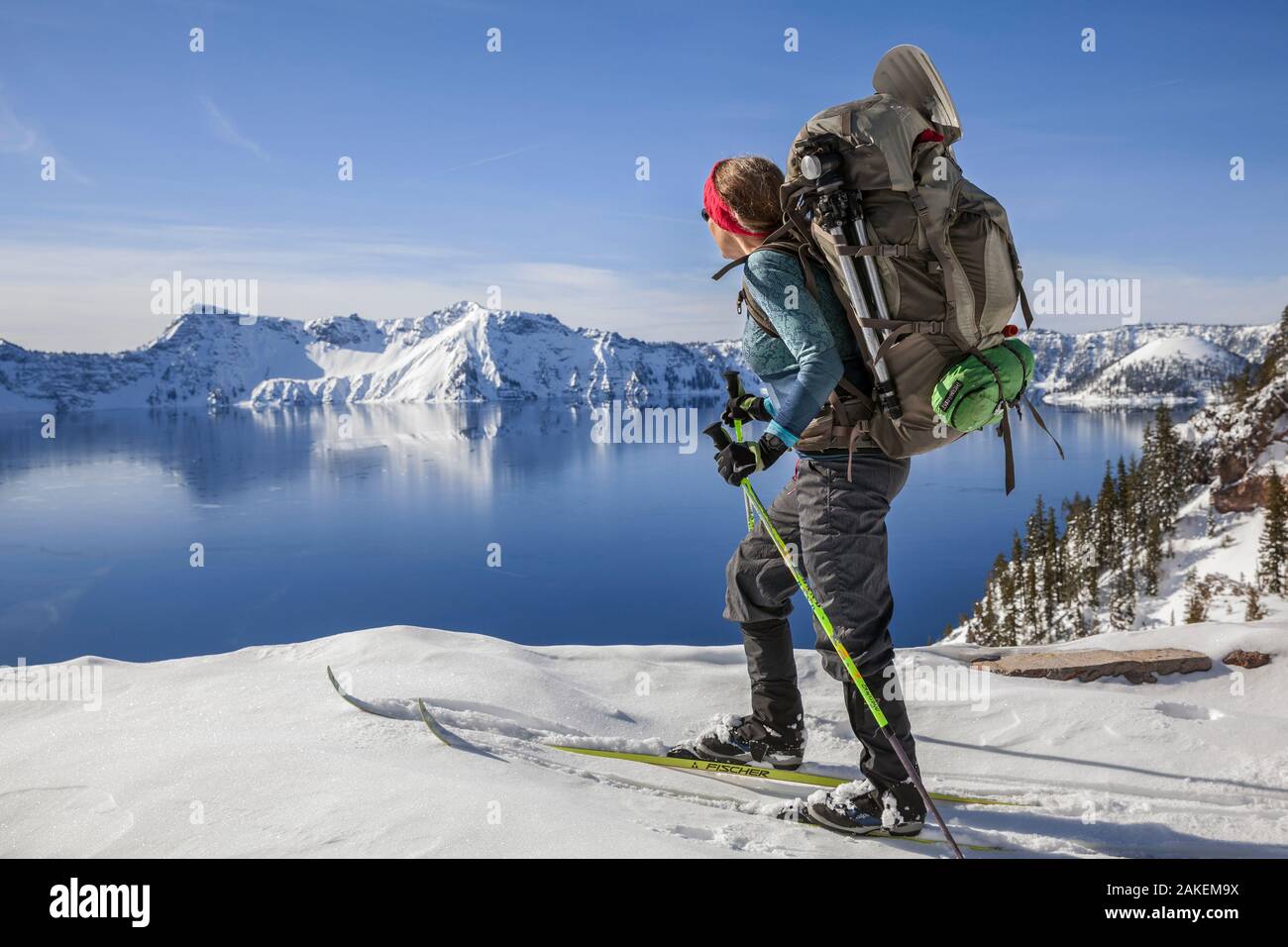 Woman cross country skiing along the north side of Rim Drive in Crater Lake National Park. Oregon, USA. March 2018. Model released. Stock Photo