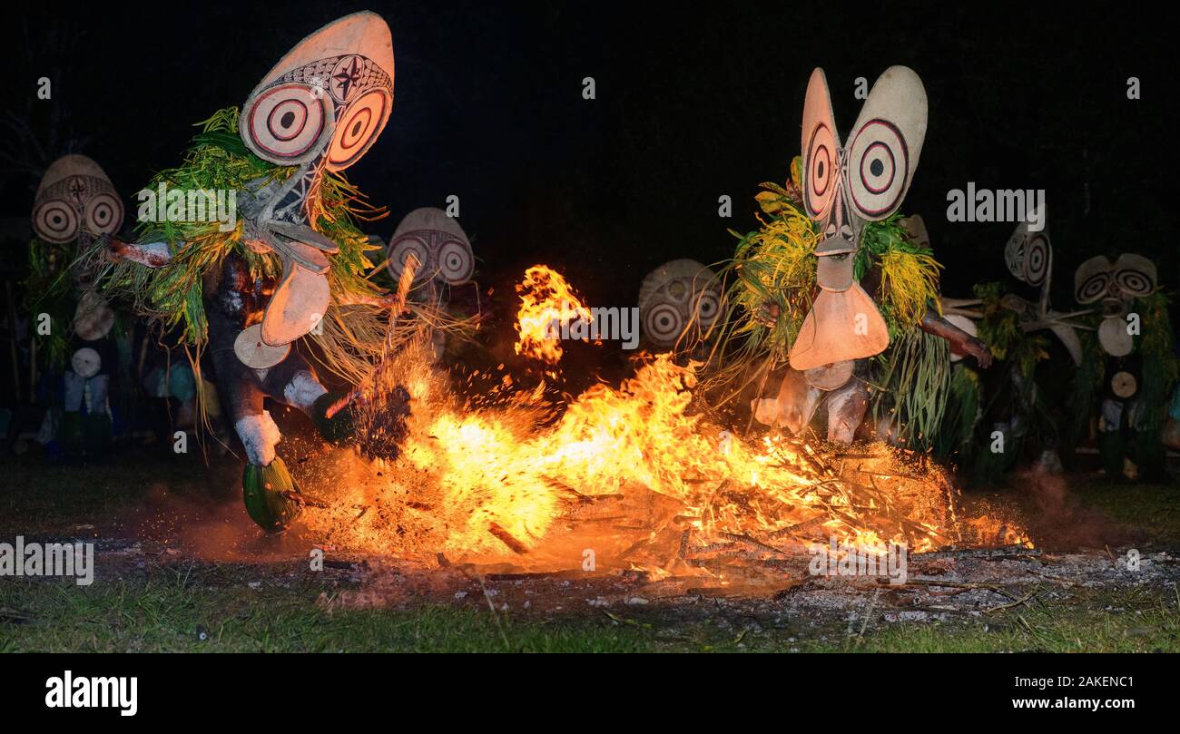 Traditional Baining Fire Dance. Performed by men from the Baining tribe who enter a trance like state and dance around and through the fire in masks thought to resemble insects to contact the spirit world. Baining Mountains, near Kokopo, New Britain,  Papua New Guinea, July 2018. Stock Photo