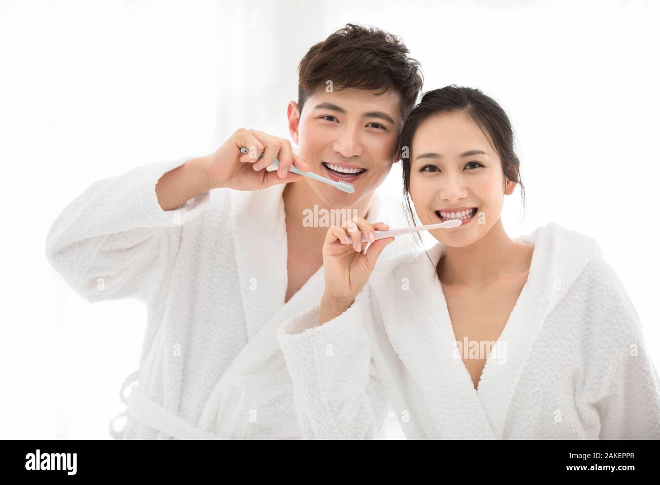 Young Chinese couple brushing teeth at home Stock Photo