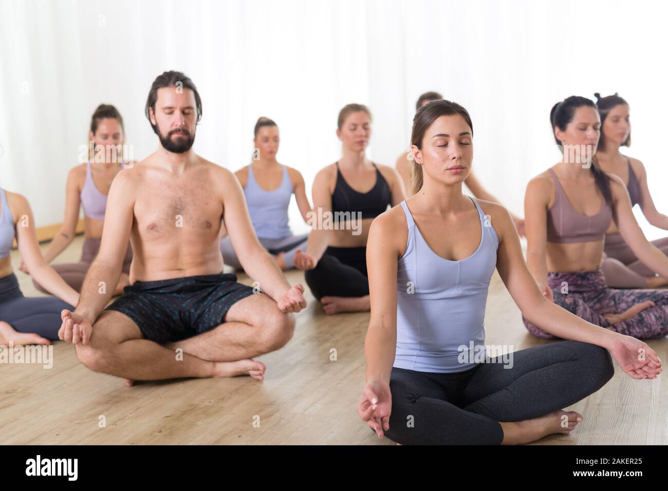 Group of attractive women practicing yoga in Easy Seat pose Stock Photo -  Alamy