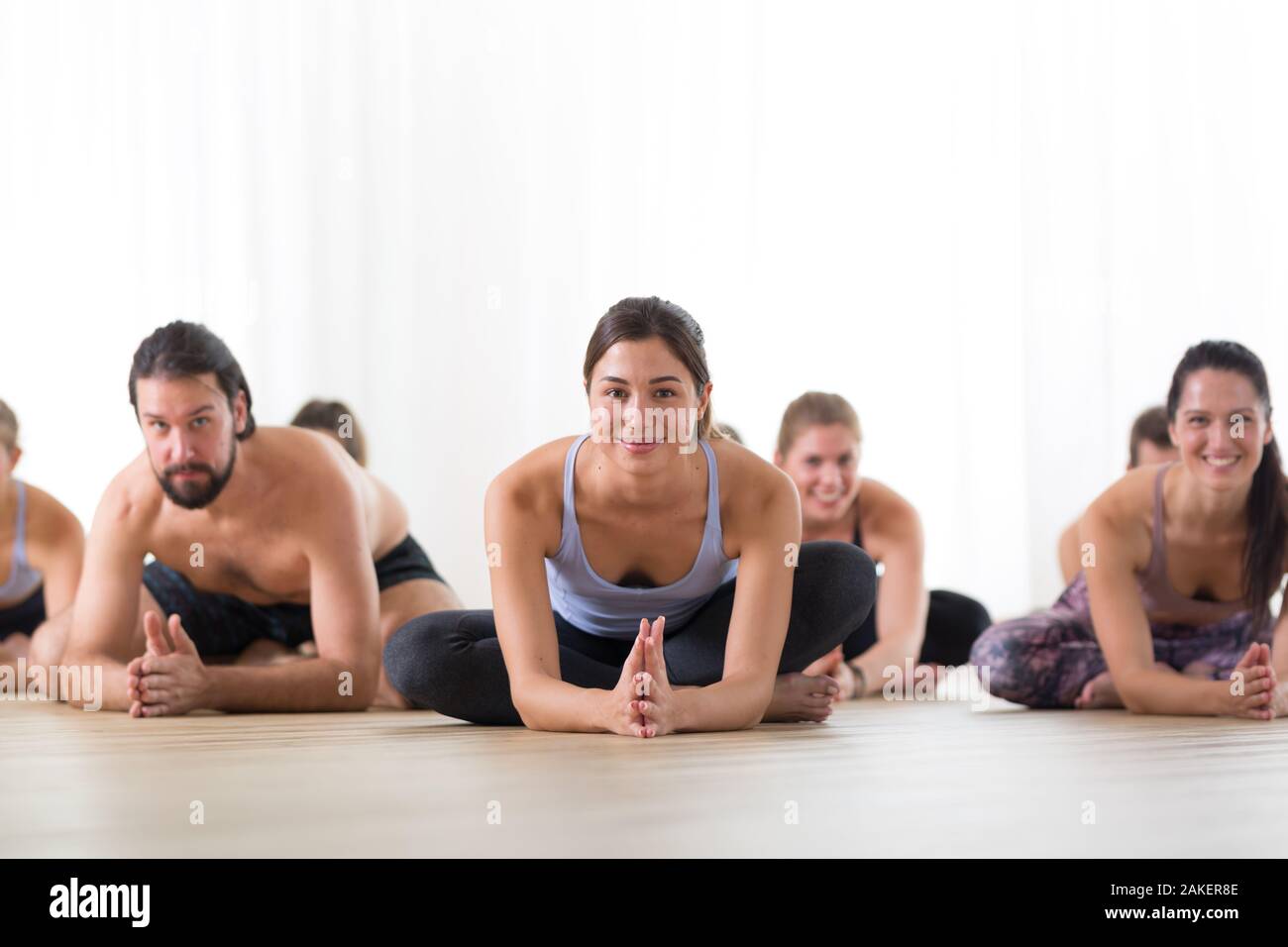 Group of sporty girls practicing wall yoga poses with straps in modern yoga  studio Stock Photo - Alamy