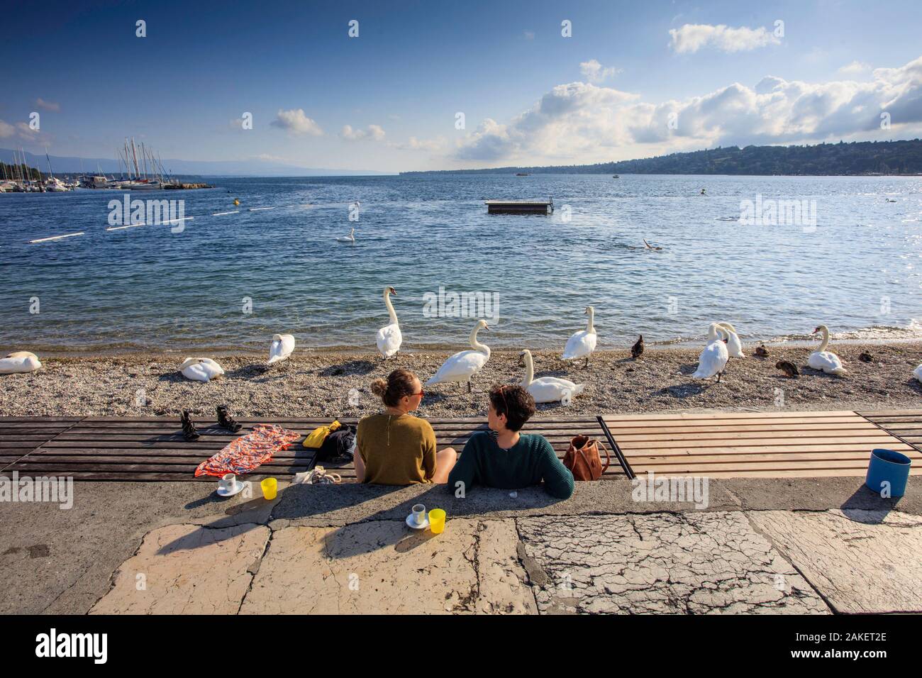 Two women have coffee on the lakeside in Bains de Paquis, Geneva, Switzerland Stock Photo