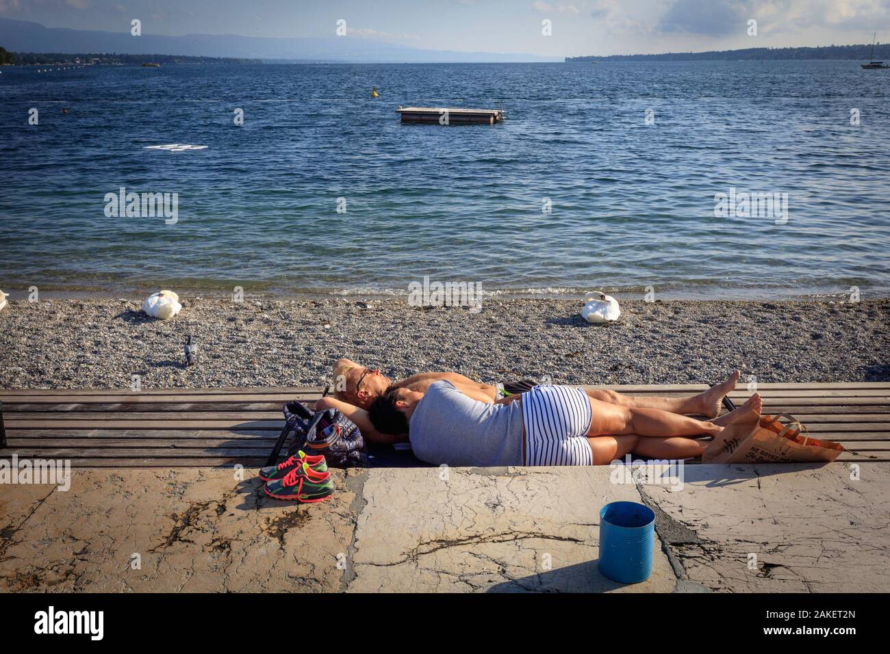 A couple lies down on the Leman lake shore, Bains de Paquis. Geneva. Switzerland Stock Photo
