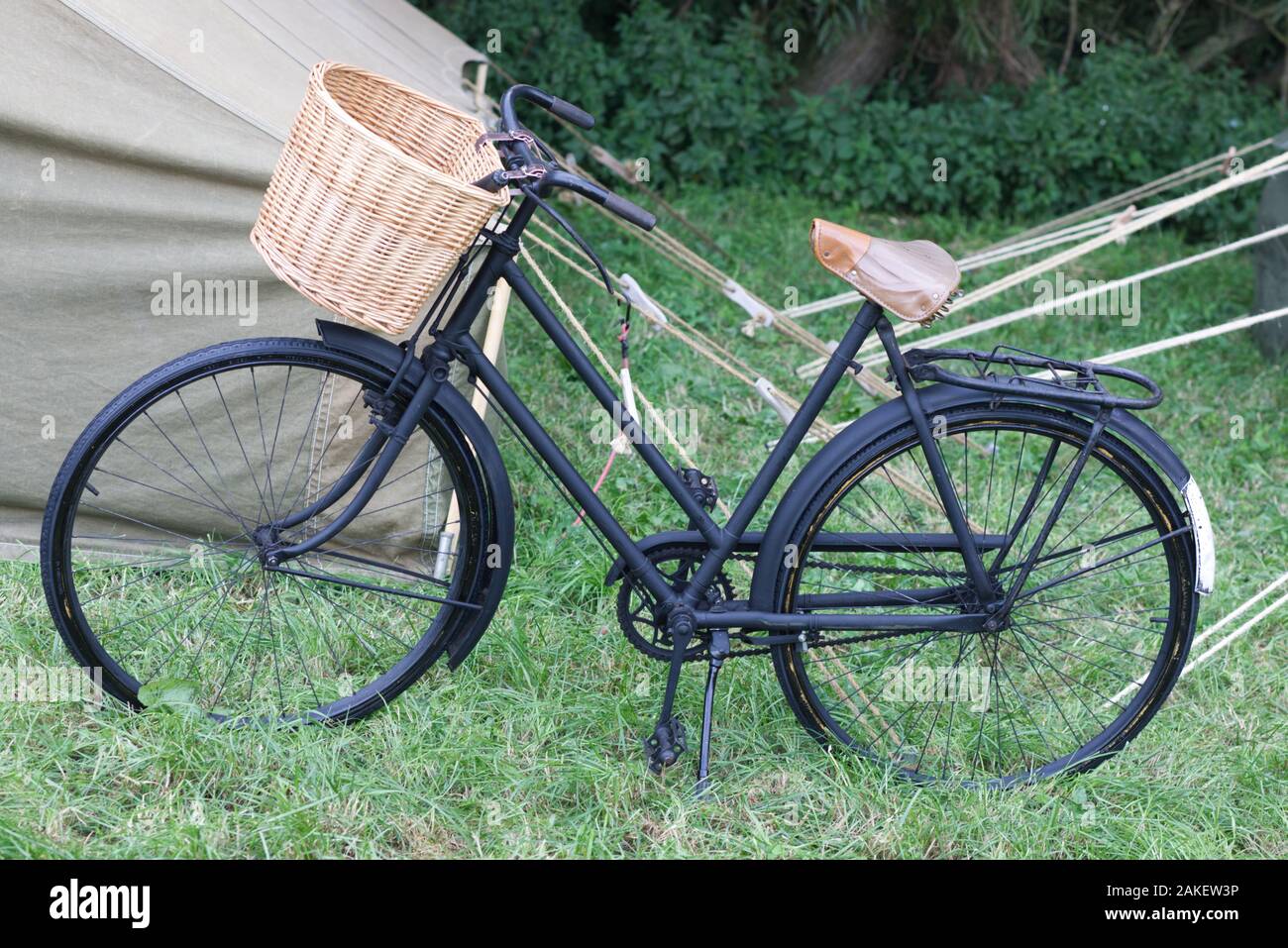 1940s blacked out push bike with wicker basket and leather saddle Stock Photo