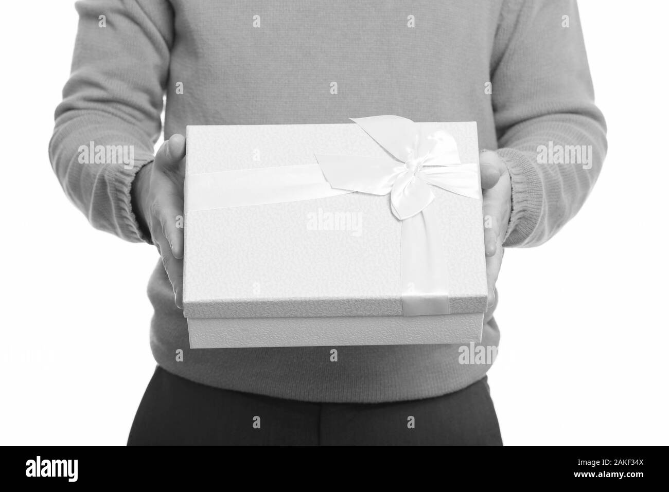Young Caucasian man giving pink gift box with white ribbon Stock Photo