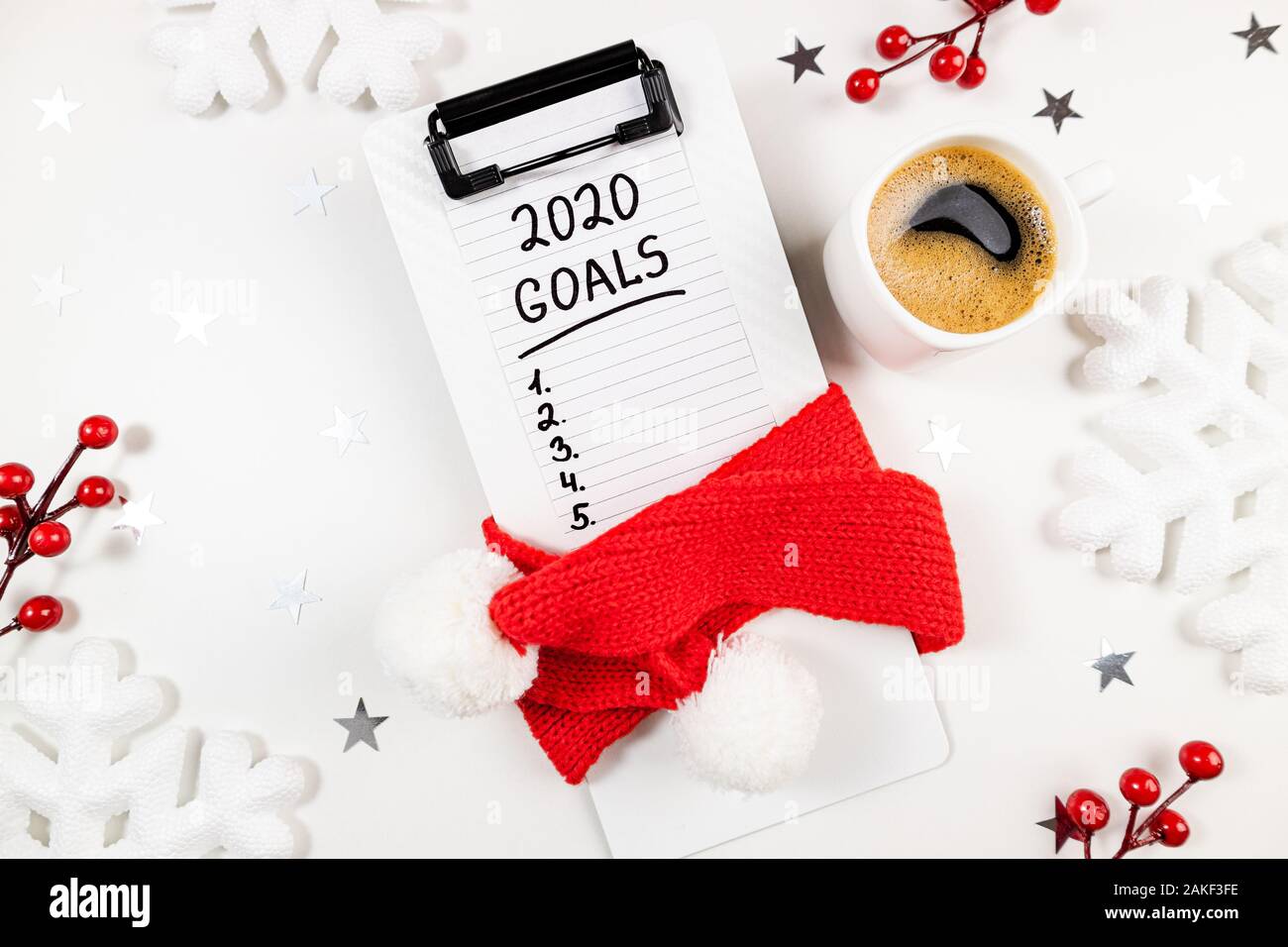 New year goals 2020 on desk. 2020 goals list with notebook, cup of coffee on white background. Goals, plan, resolutions, strategy, change, idea concep Stock Photo