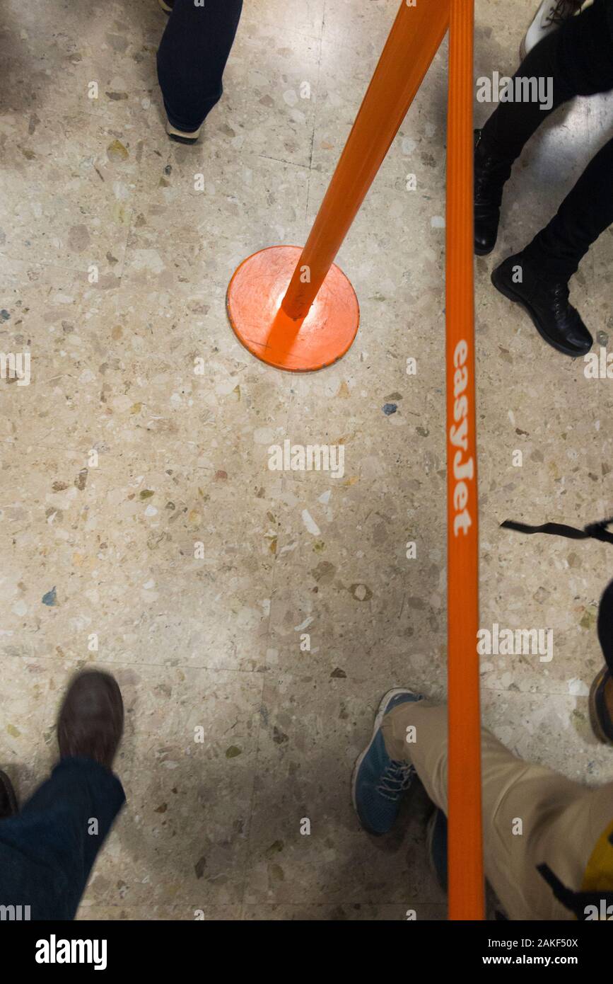 Easyjet passengers feet in queue / queuing / queues / waiting area to check in their case, luggage, suitcases / suit suitcase and hand luggage. Airport, Switzerland. (115) Stock Photo