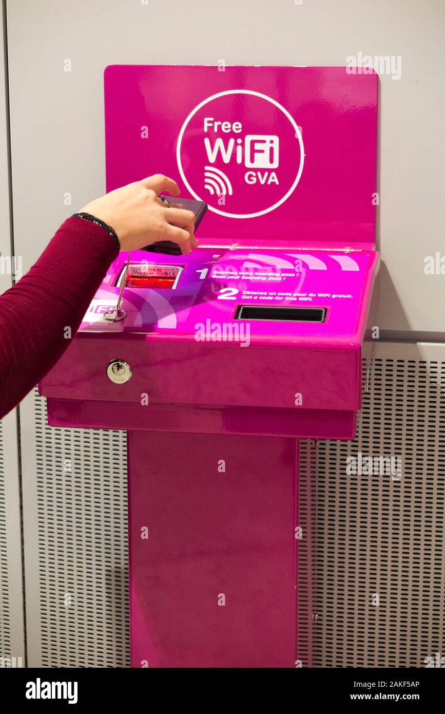 Passenger scanning her boarding pass as a machine issuing sign on code numbers / number codes to access the free passenger WiFi / Wi Fi Internet access to airport passengers. Geneva / Geneve. Switzerland (115) Stock Photo