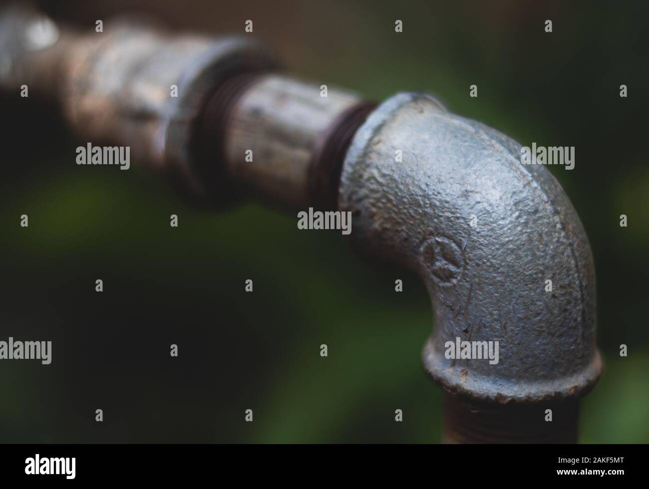 an old metal outdoor water pipe with 90 degree bend fitting that ...