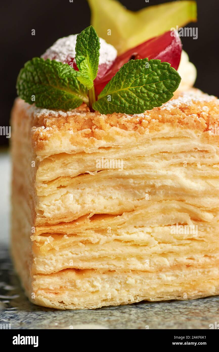 Close-up view of russian Napoleon cake decorated with fresh grape, cannon  and mint on wooden background Stock Photo - Alamy, image size:866x1390