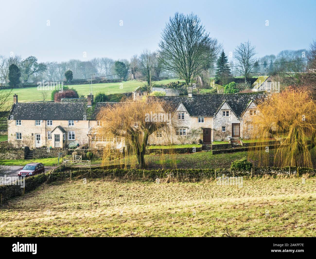 A row of pretty stone cottages in the Cotswold countryside near Northleach. Stock Photo