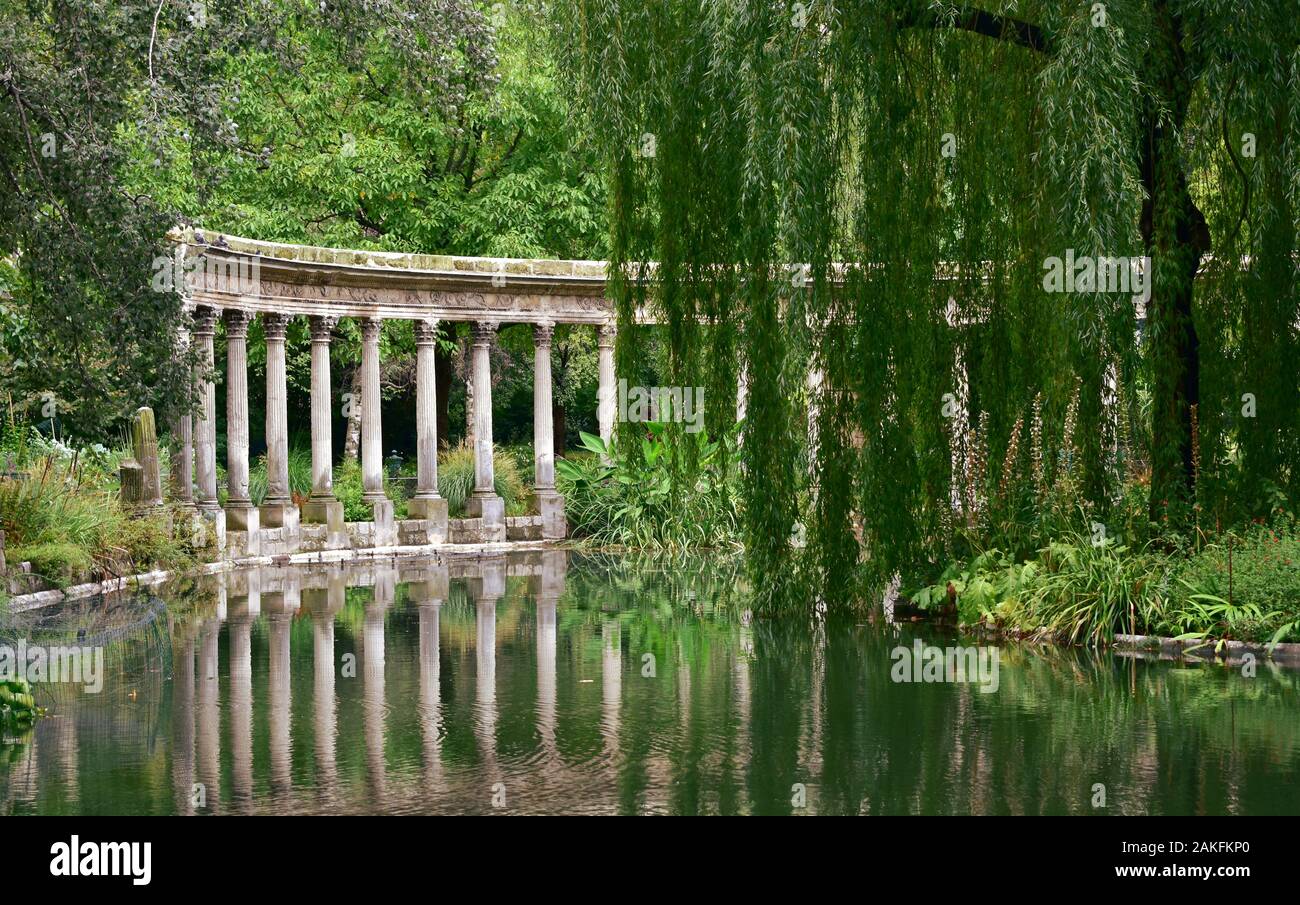 The Naumachia at Parc Monceau, classical colonnade and pond with water reflections. Paris, France. Stock Photo