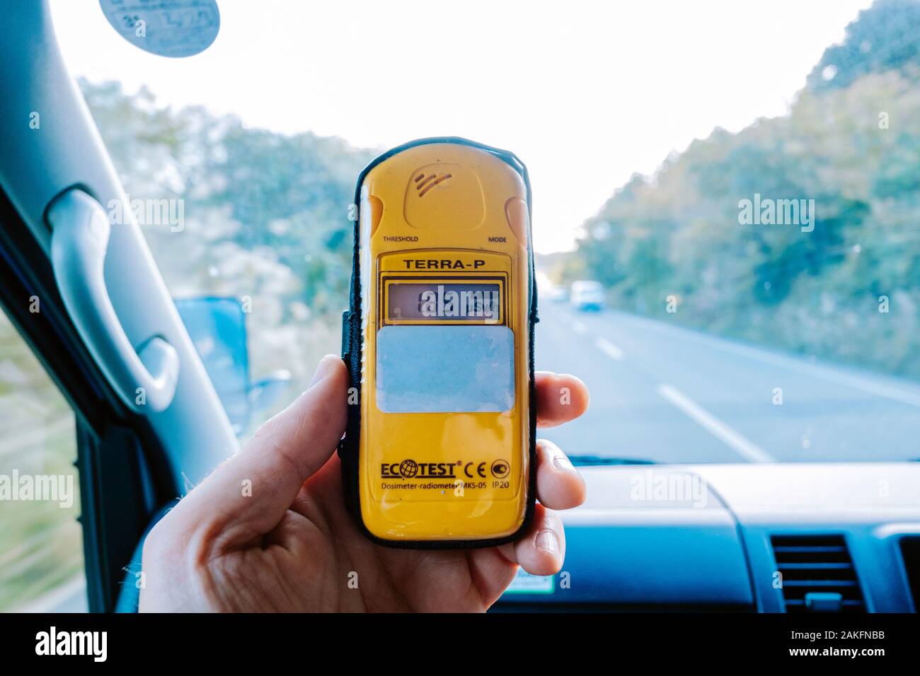 Person holding a dosimeter inside a moving car Stock Photo