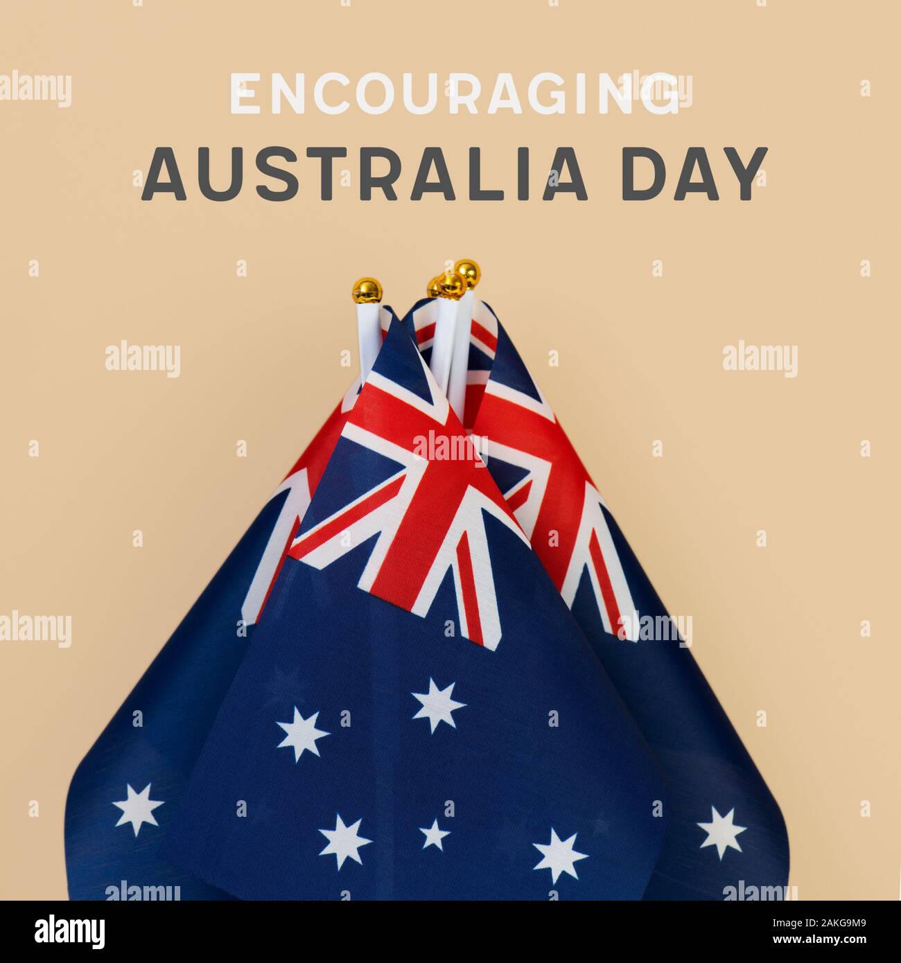 closeup of some australian flags and the text happy encouraging day against a light brown background Stock Photo