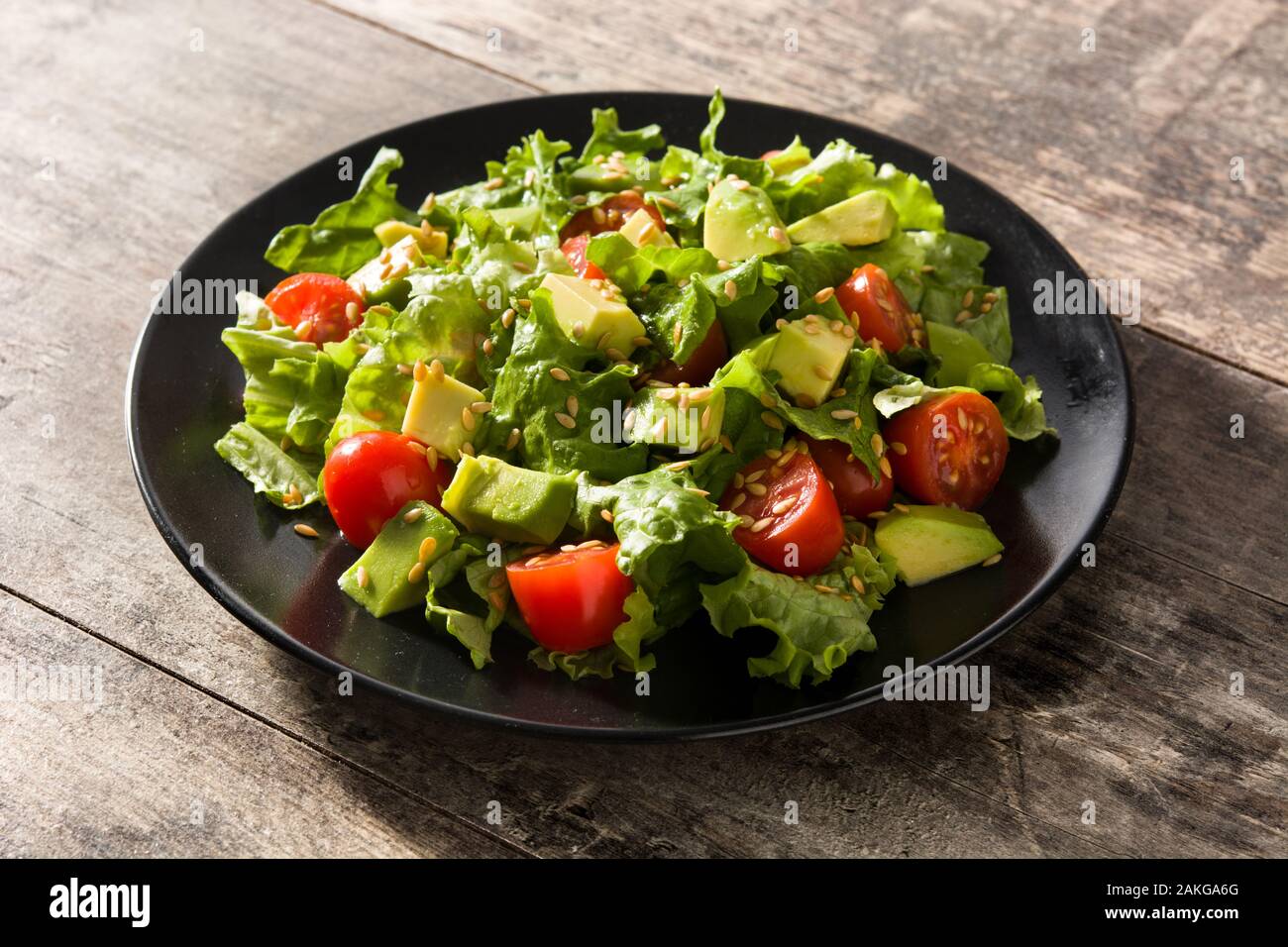 Salad With Avocado Lettuce Tomato Flax Seeds On Wooden Table Stock Photo Alamy