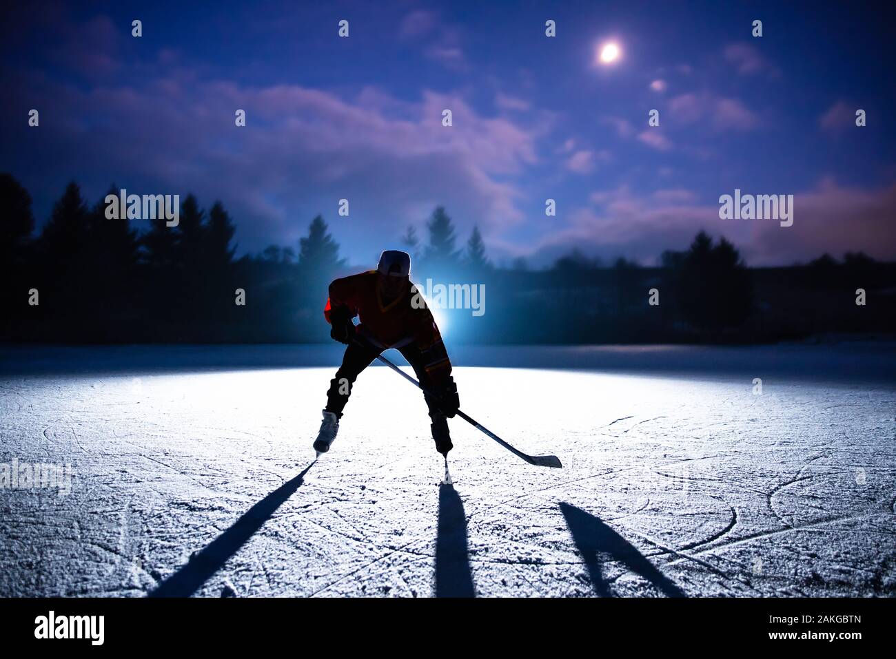 Hockey player silhouette on the dark night . Stock Photo