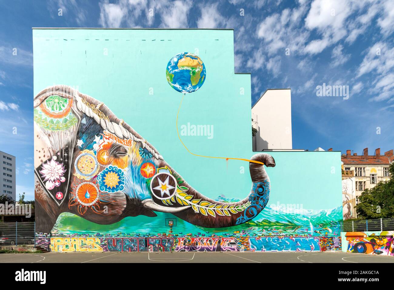Wide angle view of a huge graffiti on the side of a high rise building portraying a colorful elephant against a light blue background Stock Photo