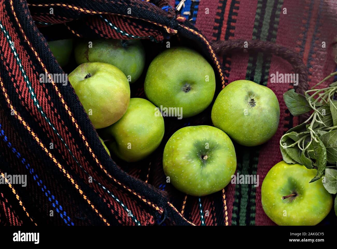 Green apples in a hand-woven bag; Stock Photo
