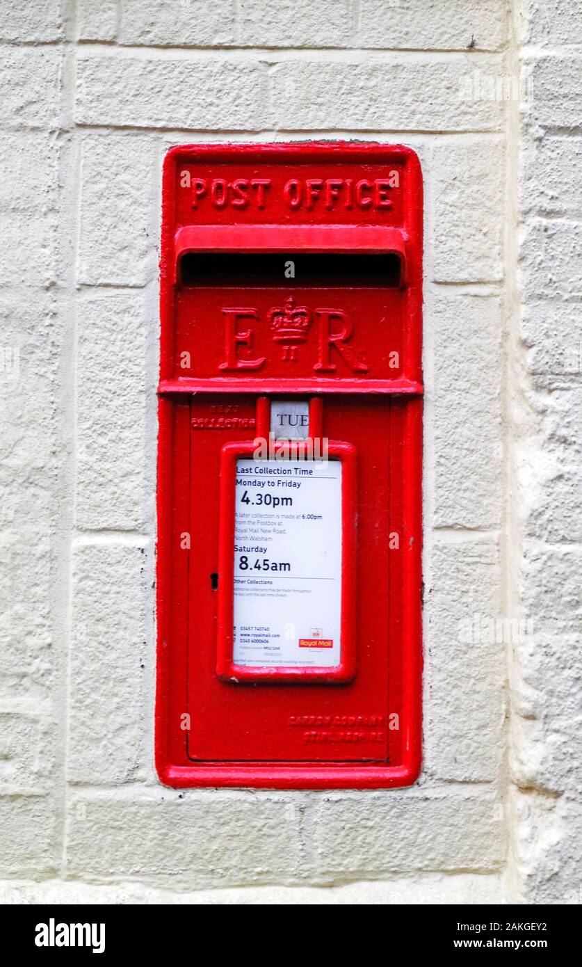A red postbox positioned in a wall by the roadside in the village of Belaugh, Norfolk, England, United Kingdom, Europe. Stock Photo