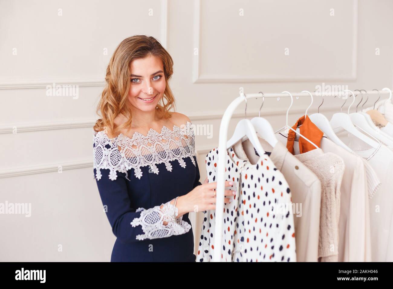 Young woman choosing clothes on a rack for the party Stock Photo