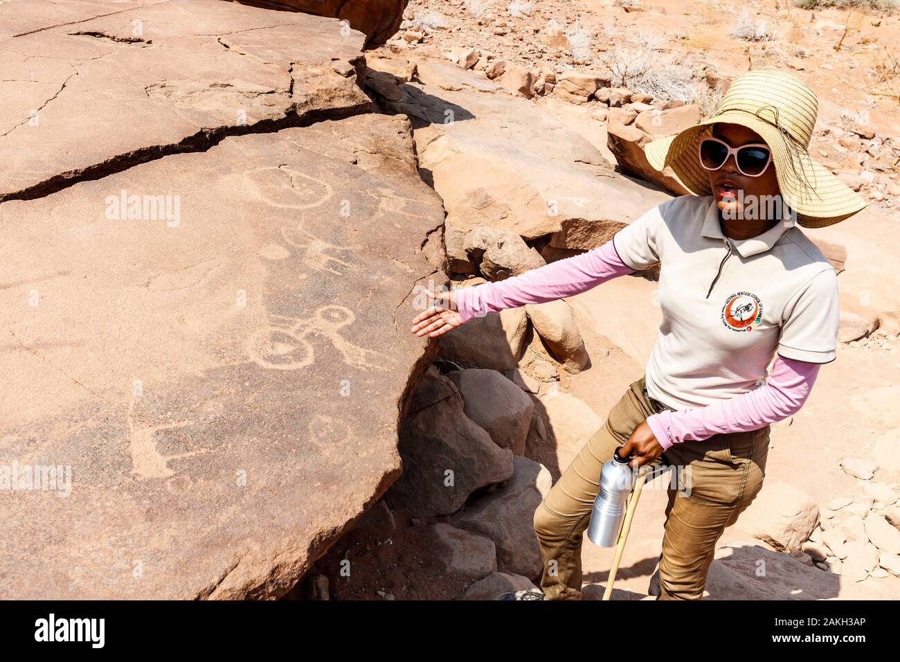 Namibia, Kunene province, Twyfelfontein, listed as World Heritage by UNESCO, guide providing informations on rock engravings to tourists Stock Photo