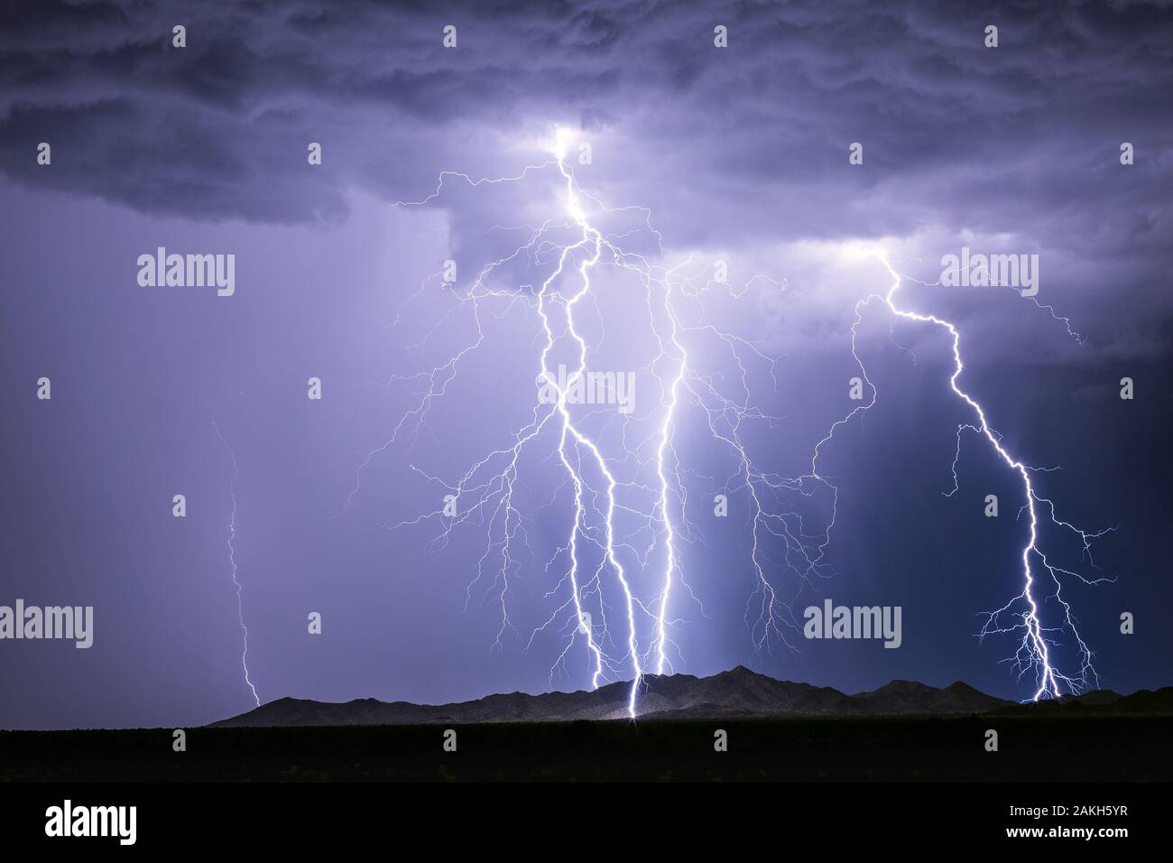 A series of lightning bolt strikes hitting a mountain in a storm near Phoenix, Arizona Stock Photo