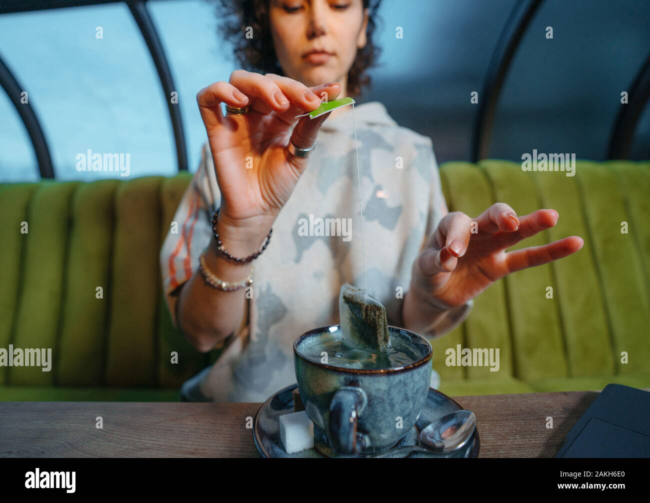 Woman brewing a fresh mug of tea with teabag in a cafe Stock Photo