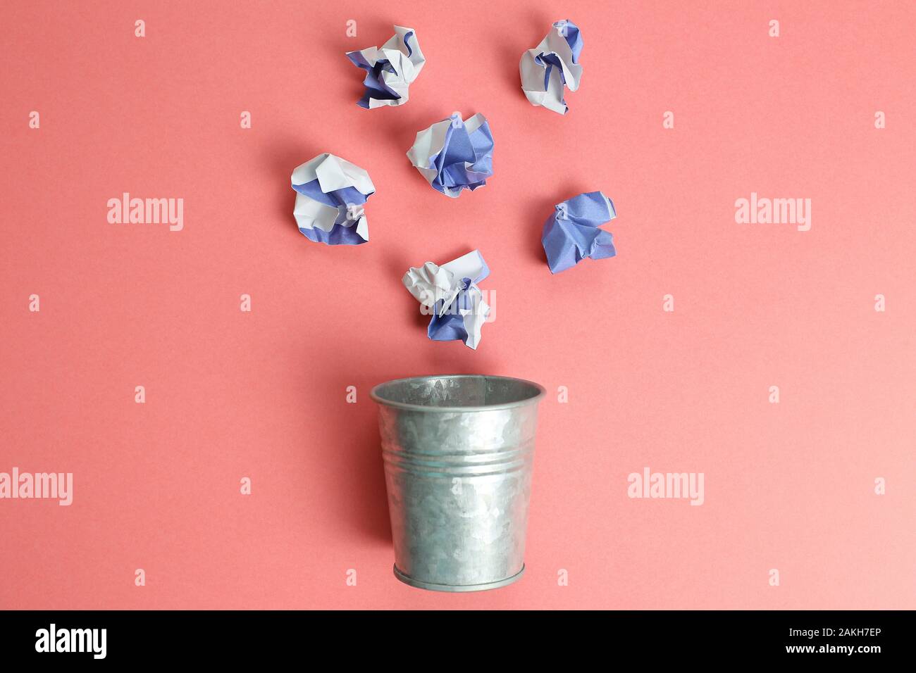 Trash can with trash on pink background Stock Photo