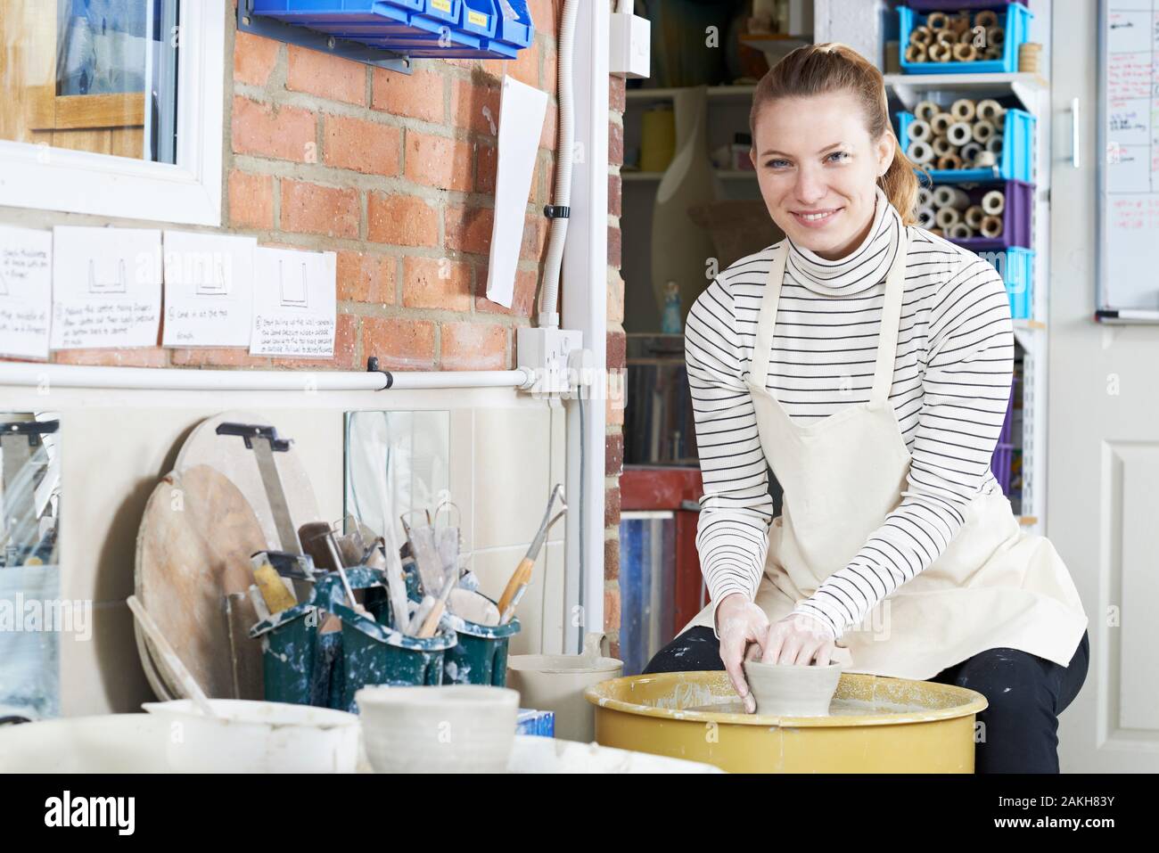 Portrait Of Woman Working At Pottery Wheel In Studio Stock Photo
