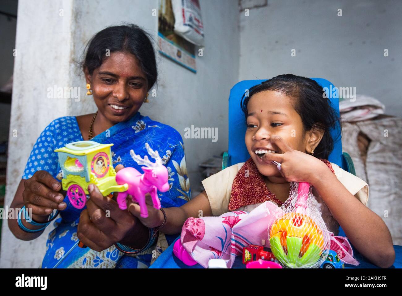CAPTION: Home-Based Educator (HBE) Sakamma has been able to help eight-year-old Sangeetha, who has cerebral palsy, improve her fine motor skills by pl Stock Photo