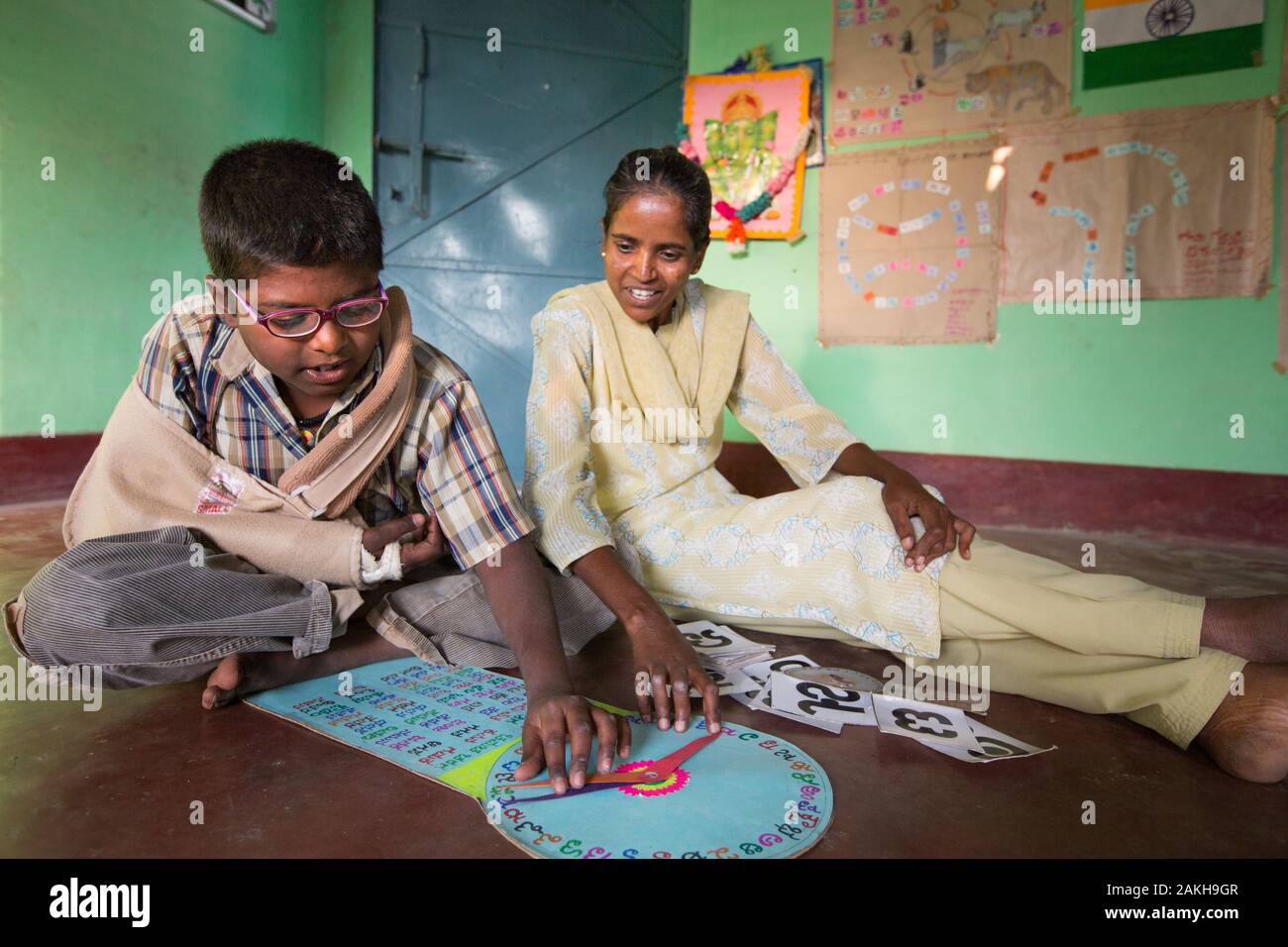 CAPTION: After-School Club (ASC) Coordinator Doddamma, who herself has rheumatoid arthritis, works on an activity designed under a visually impaired c Stock Photo