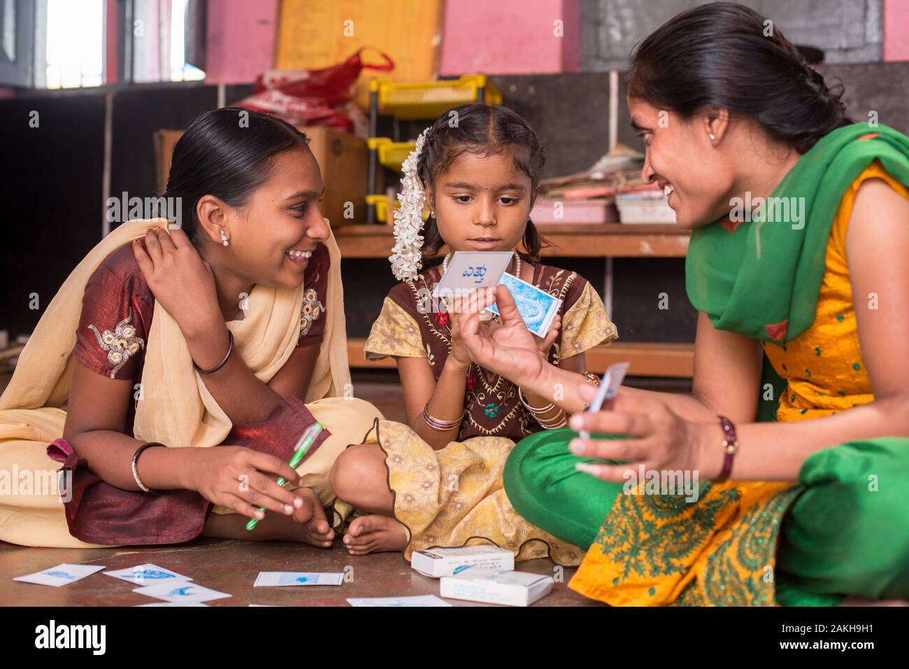 CAPTION: After-School Club (ASC) Coordinator Asha, who herself has scoliosis, leads children in a card game. The game is very visual, designed to be i Stock Photo