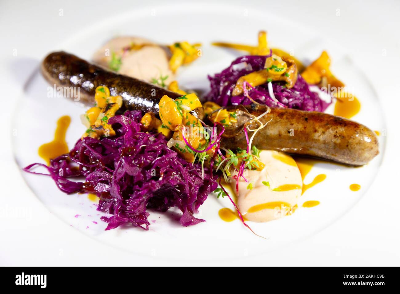 Grilled bratwurst style sausage served at Zell am See, Austria.  It is accompanied by red cabbage and seasonal vegetables. Stock Photo