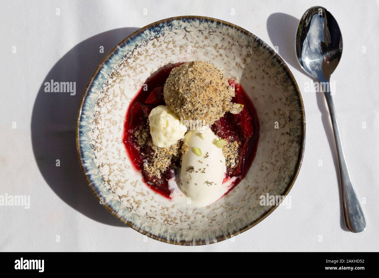 A dessert featuring ice cream, fruit sauce and a form of dumpling served in Zell am See, Austria. It is served in a handcrafted bowl. Stock Photo