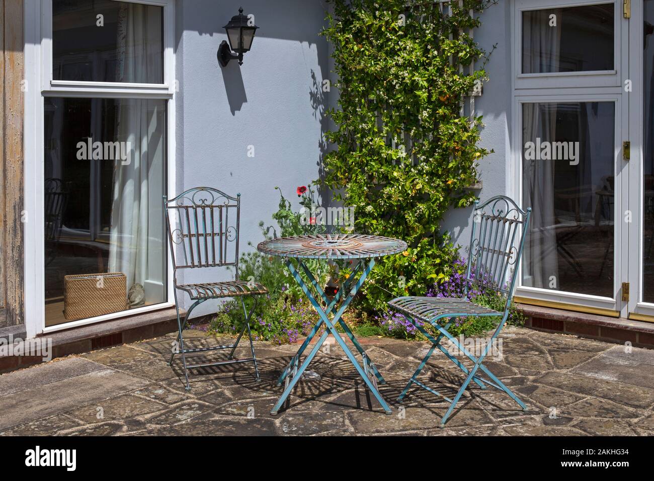 Metal garden seating furniture on stone patio in English summer garden