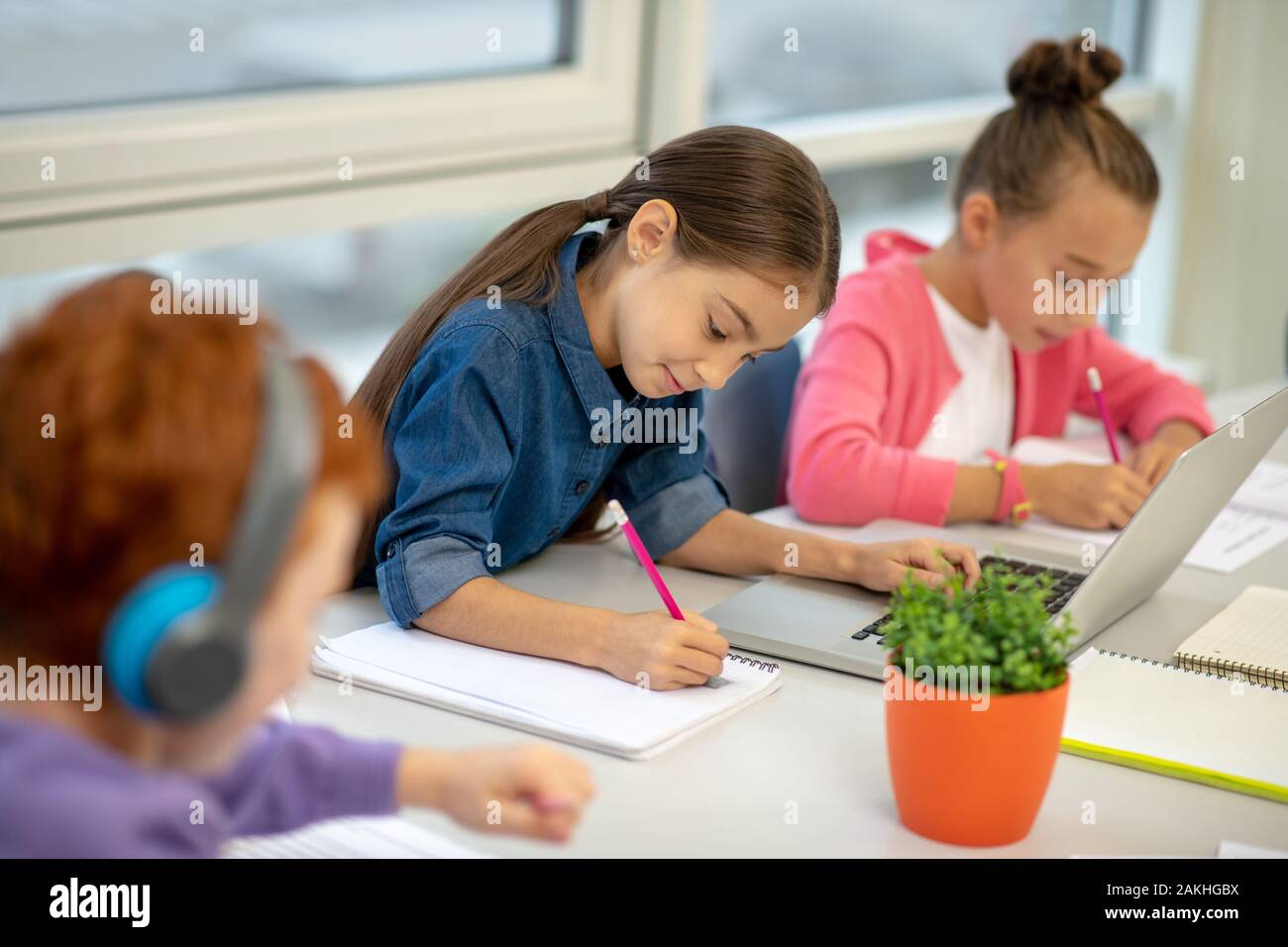 Children working at the lesson using helpful devices Stock Photo