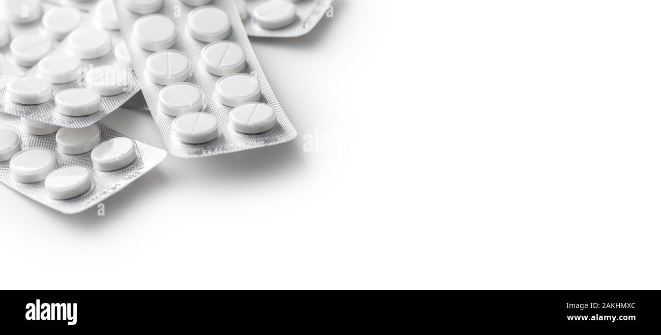 Heap of white medical pills in plastic package Stock Photo