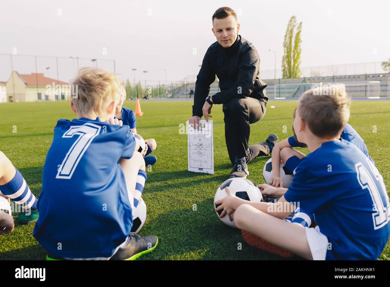 Young Coach Explaining Soccer Positions and Match Tactics to Youth