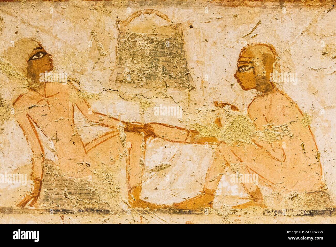 Luxor in Egypt, Valley of the Nobles, tomb of Menna. Detail of an agricultural scene, a girl removes a thorn from the foot of the other. Stock Photo
