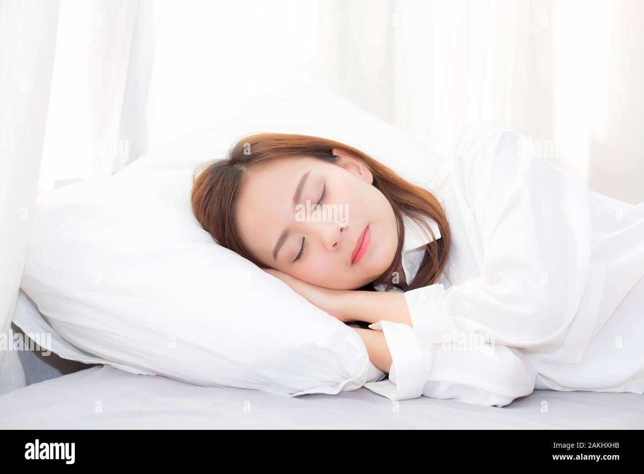 Beautiful asian young woman sleeping lying in bed on bedroom with head on pillow comfortable and happy, girl with relax for health welness and lifesty Stock Photo