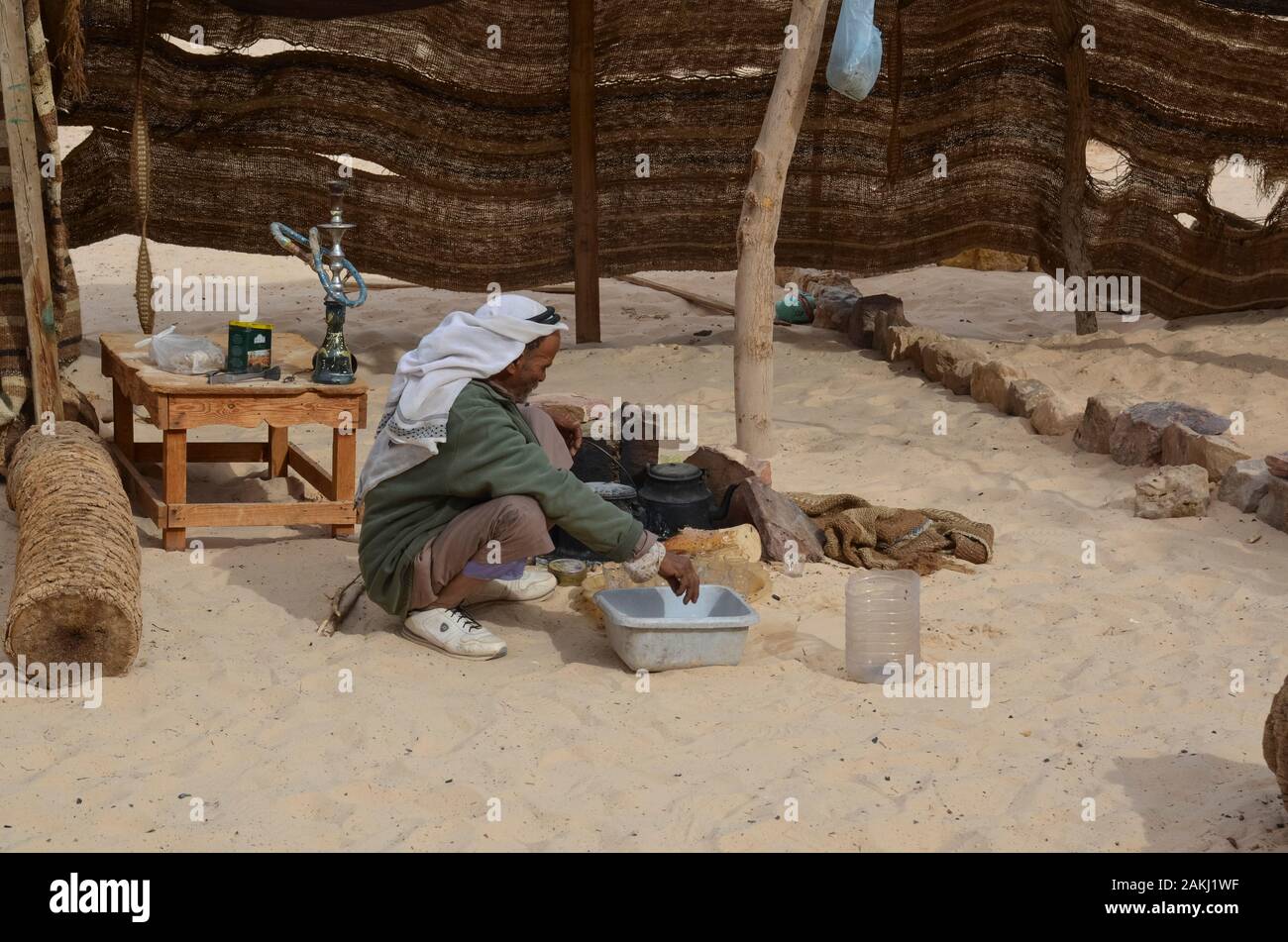 Eastern Desert, Egypt - January 24, 2013: Eastern Desert, Egypt - January 24, 2013: Bedouin man preparing food in the desert of Egypt Stock Photo