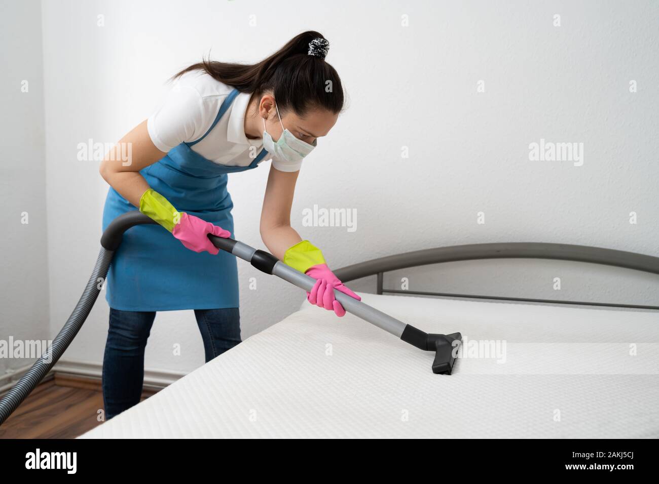Mattress Cleaning Professional Service By Female Cleaner Using Vacuum Cleaner Stock Photo