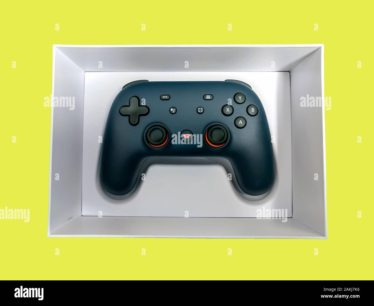 Seattle, WA / USA - circa November 2019: Closeup of a Google Stadia gaming controller inside a white box against a colorful background Stock Photo