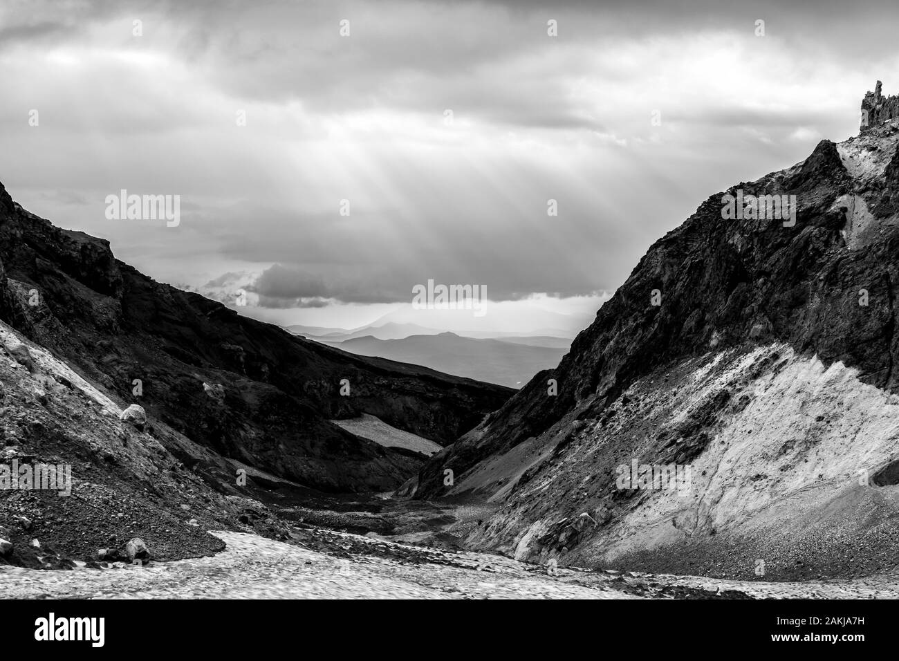 Black and white dramatic mountain landscape. The rays of the sun breaking through the clouds. Stock Photo