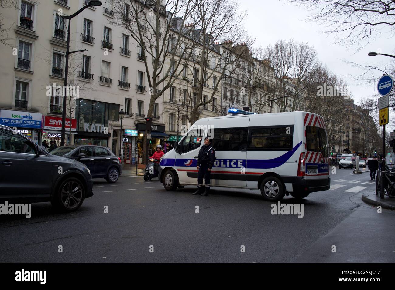 French police van parked in road, closing road to traffic, as police officer stands by, in anticipation of protests due to government's proposed pension reforms, causing travel disruption, Paris strike (la grève), boulevard Barbès, 75018, Paris, France, 9th January 2020 Stock Photo