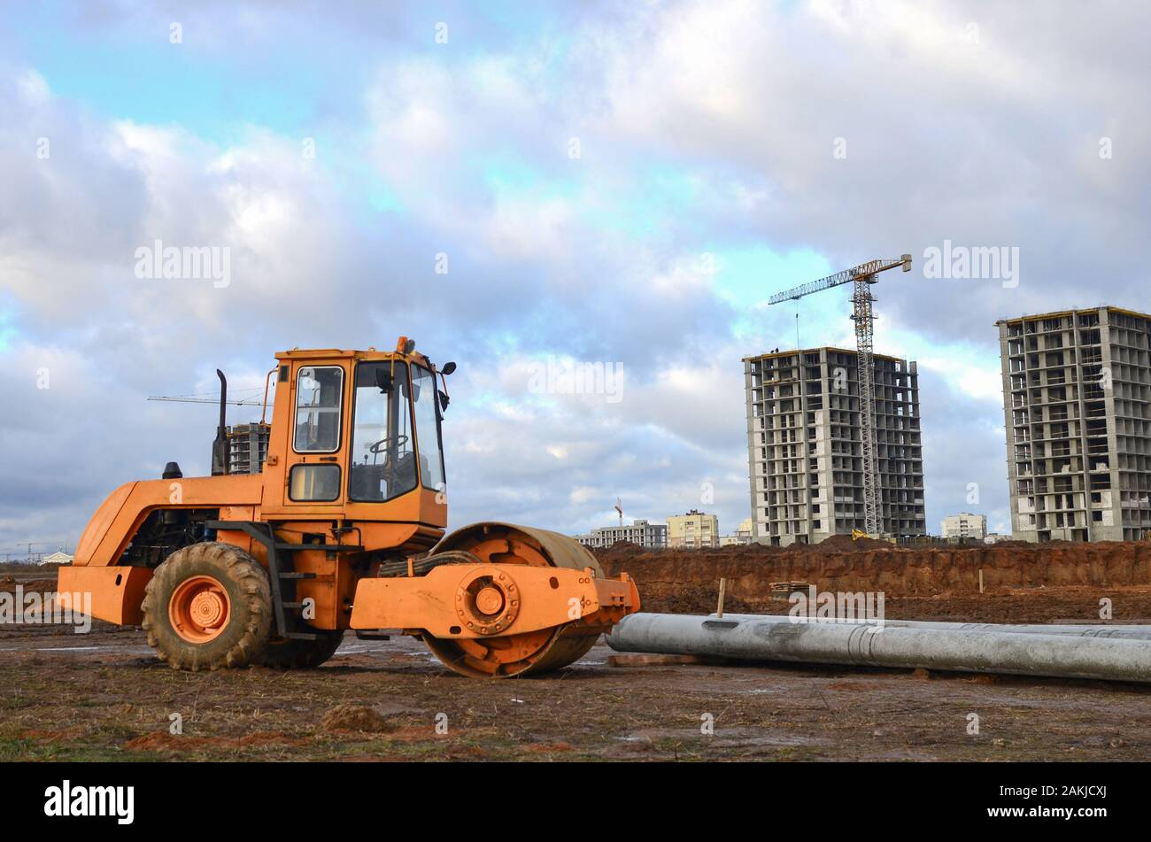 Vibration single-cylinder road roller leveling the ground for the construct of the foundation for residential building, office, shopping center. Soil Stock Photo