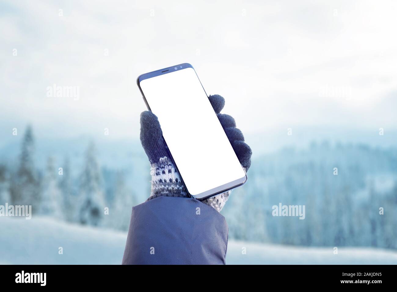 Phone mockup in hand. Winter time with lot of snow. Concept of using ...