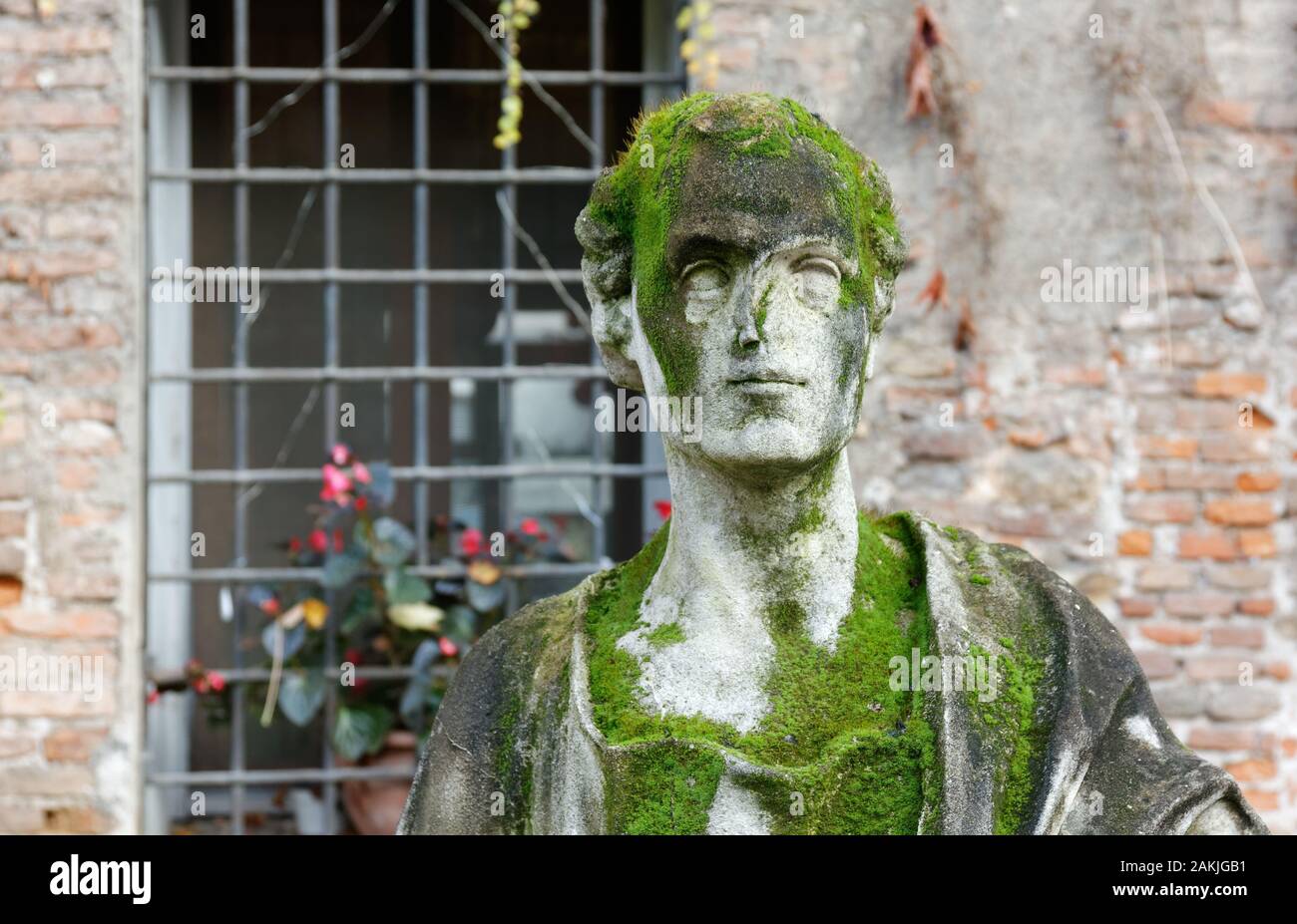 Stone statue covered in moss in the courtyard of Territorio palace in